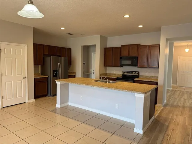 a kitchen with stainless steel appliances a refrigerator and a stove top oven