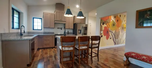 a kitchen with stainless steel appliances granite countertop a stove a sink and a microwave