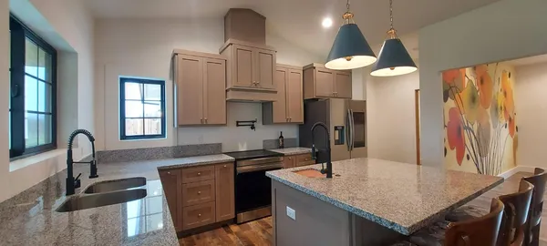 a kitchen with granite countertop stainless steel appliances a stove a sink and a microwave