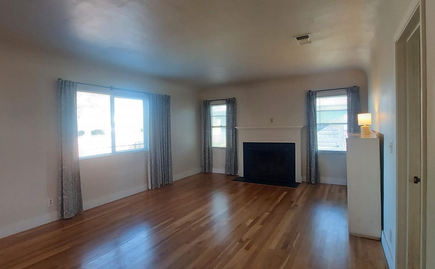 1102 Barry Road Yuba City, CA 95991 - Photo 51 of 72 an empty room with wooden floor fireplace and windows