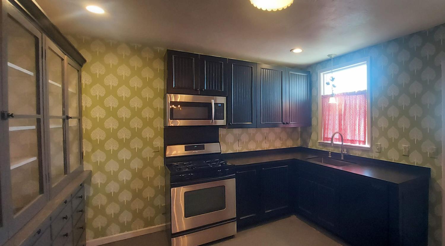 1102 Barry Road Yuba City, CA 95991 - Photo 60 of 72 a kitchen with stainless steel appliances granite countertop a stove a sink and a microwave