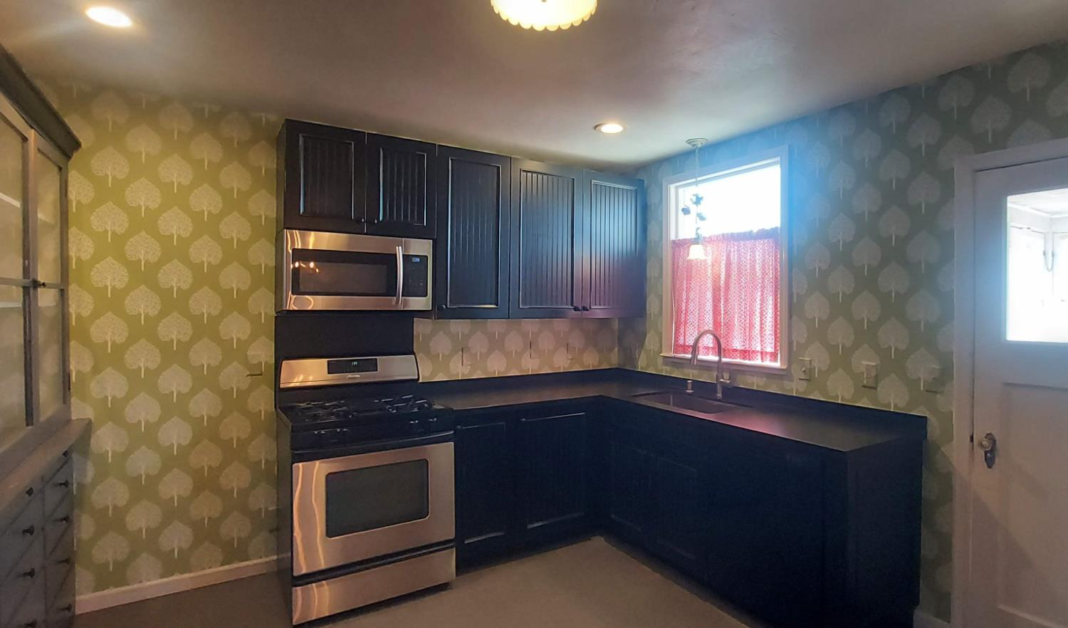 1102 Barry Road Yuba City, CA 95991 - Photo 61 of 72 a kitchen with granite countertop stainless steel appliances a stove a sink and a microwave