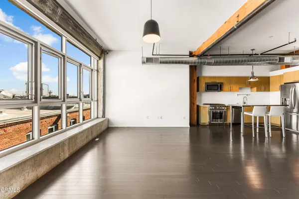 a view of empty room with wooden floor and windows