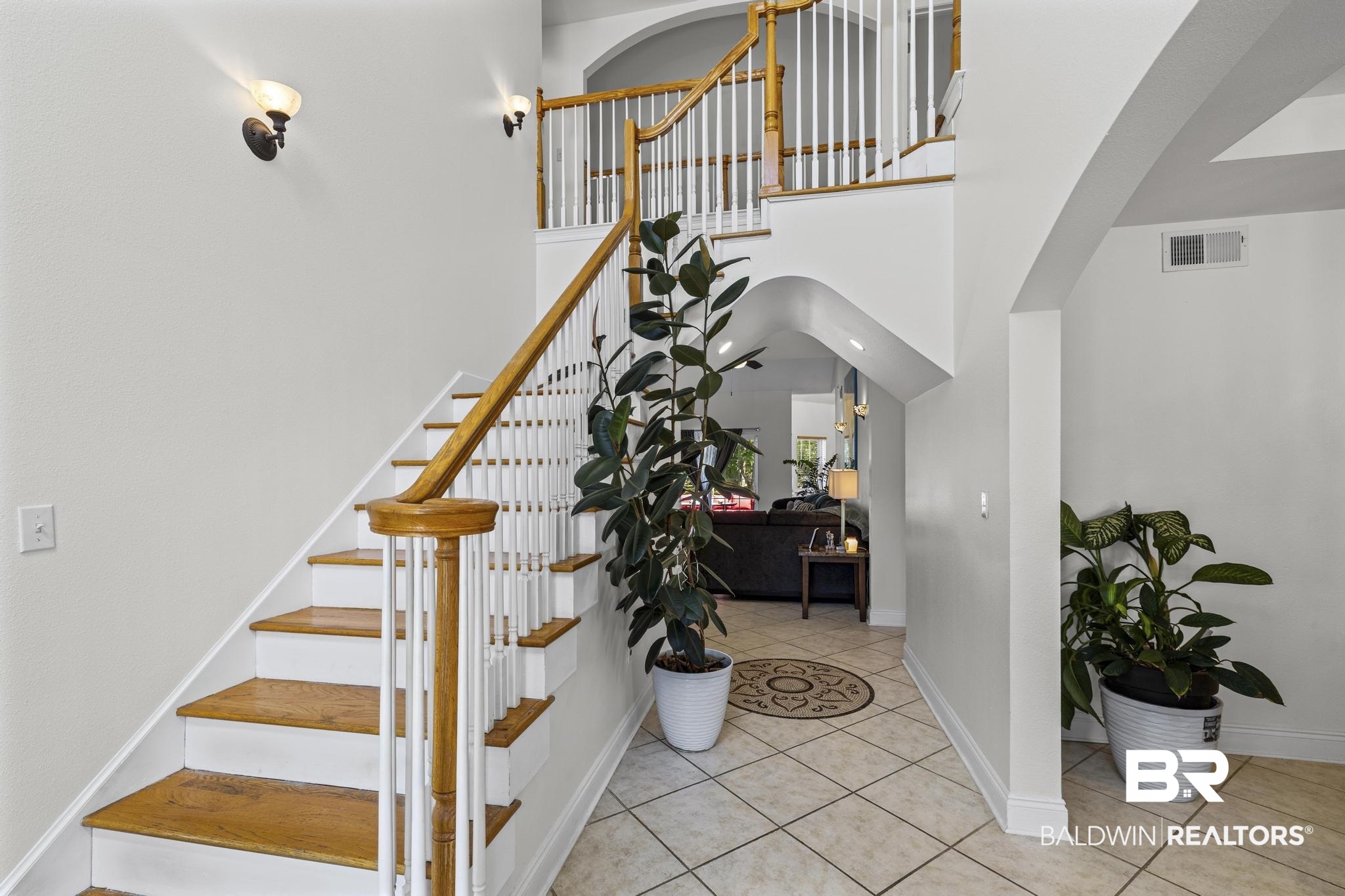 32875 Faircloth Road Lillian, AL 36549 - Photo 16 of 85 Staircase featuring tile patterned flooring, a high ceiling, and arched walkways