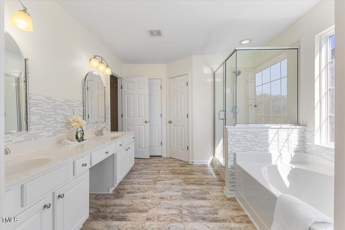 5415 Regatta Way Raleigh, NC 27613 - Photo 27 of 40 a large bathroom with a tub sink shower and mirror