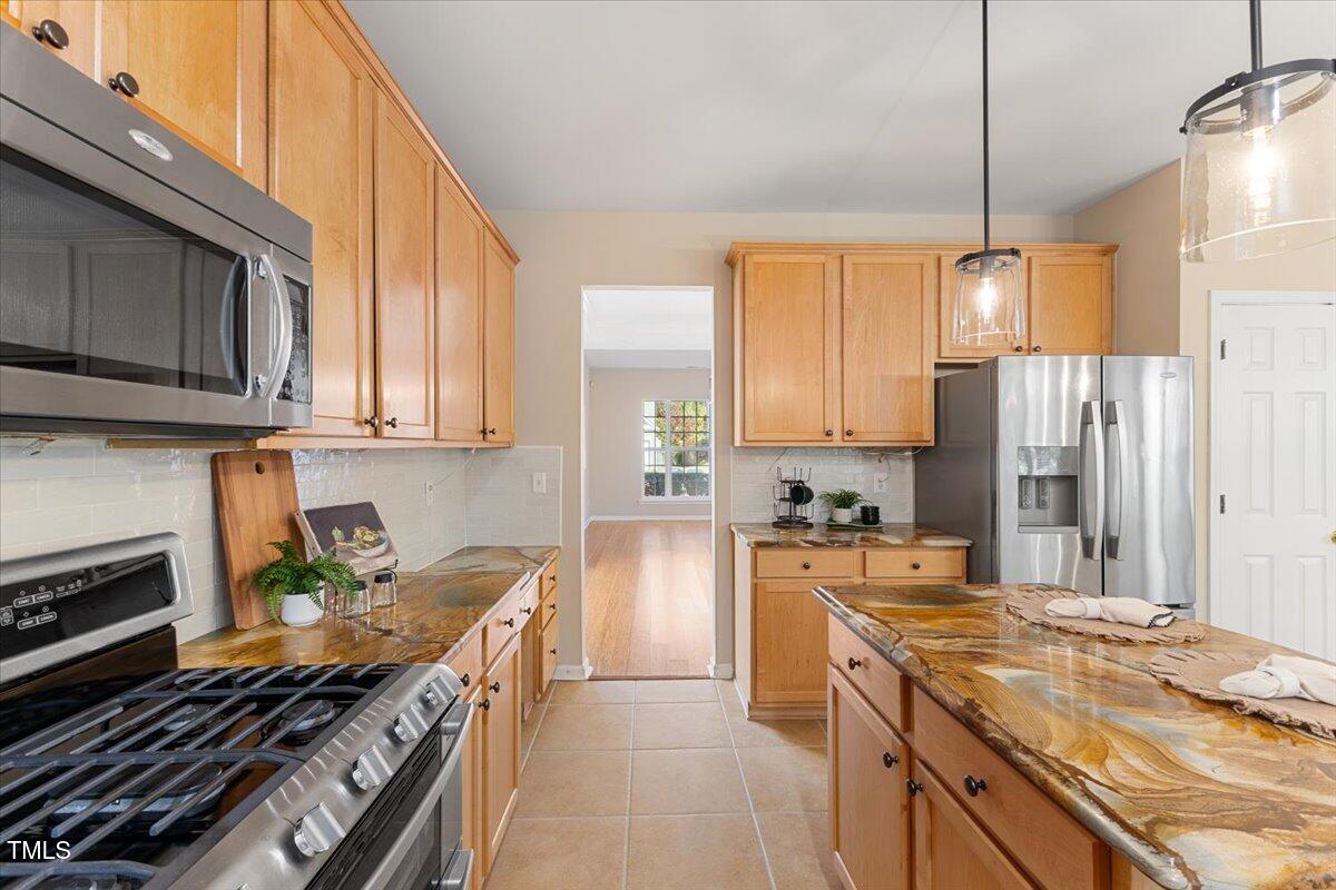 5415 Regatta Way Raleigh, NC 27613 - Photo 9 of 40 a kitchen with stainless steel appliances granite countertop a stove a sink and a refrigerator