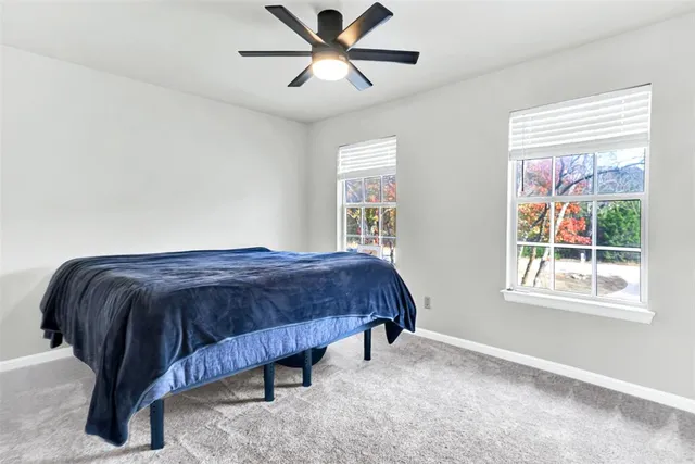 a spacious bedroom with a bed and a window