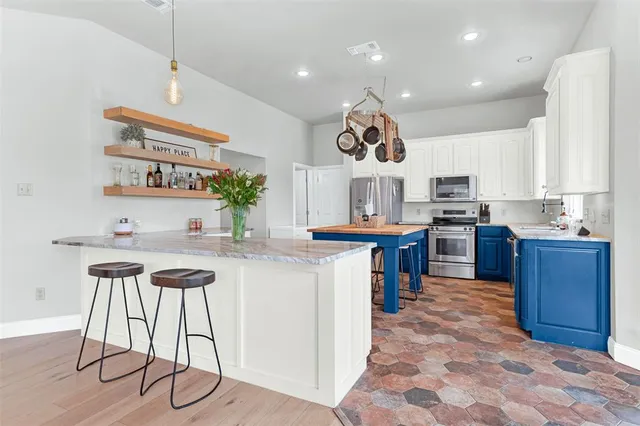 a kitchen with stainless steel appliances granite countertop a sink and a refrigerator