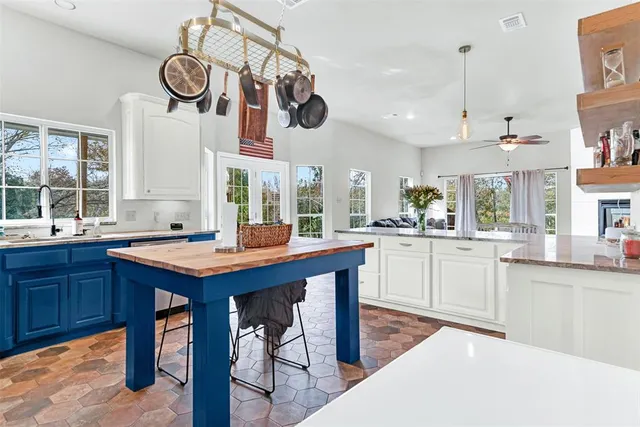 a kitchen with a counter space cabinets stainless steel appliances and a window