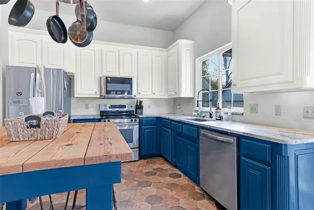a kitchen with stainless steel appliances granite countertop a sink a stove and a microwave