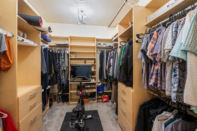 a view of walk in closet with clothes and shoes