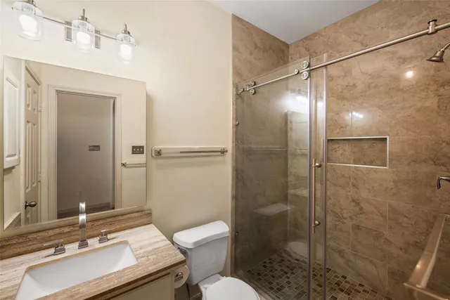 a bathroom with a sink toilet a mirror and shower