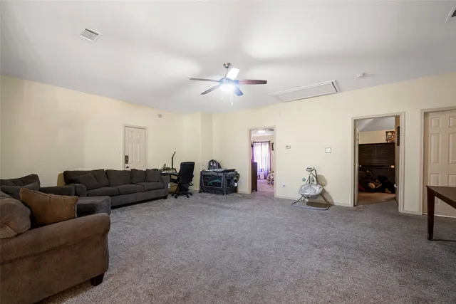 a living room with furniture and a ceiling fan