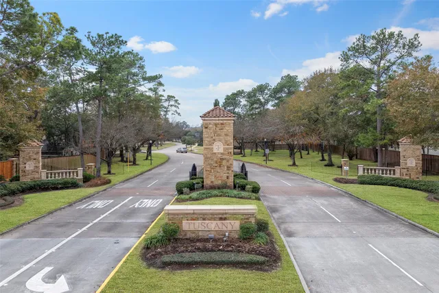 a view of a park with large trees and a cars park bench