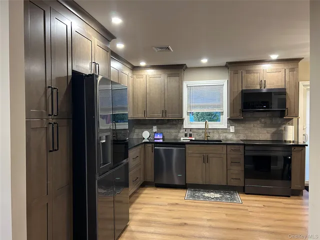 a kitchen with stainless steel appliances granite countertop a refrigerator and a stove
