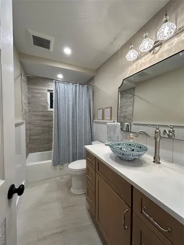 a bathroom with a sink a toilet a mirror and shower