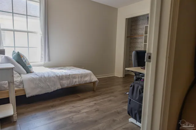 a bedroom with a bed and a large window