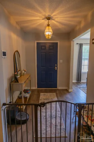 a view of a hallway with wooden floor and stairs