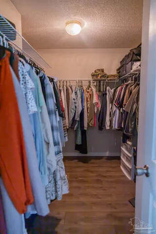 a view of walk in closet with clothes