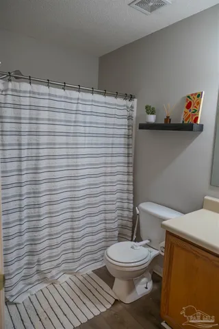 a bathroom with a toilet and a shower curtain