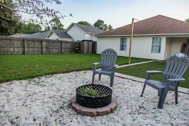 a view of a house with backyard sitting area and garden