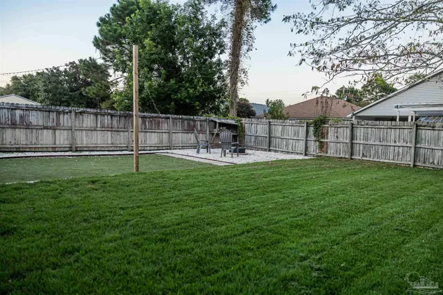 a view of a backyard with wooden fence and a slide