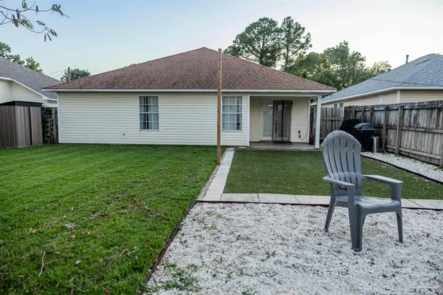 a backyard of a house with table and chairs
