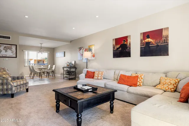 a living room with furniture a bookshelf and a large window