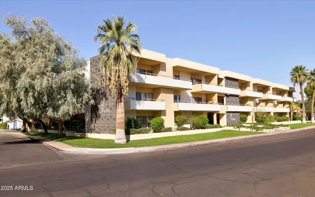 a multi story building with trees in front of it