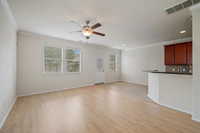a view of an empty room with a window and wooden floor