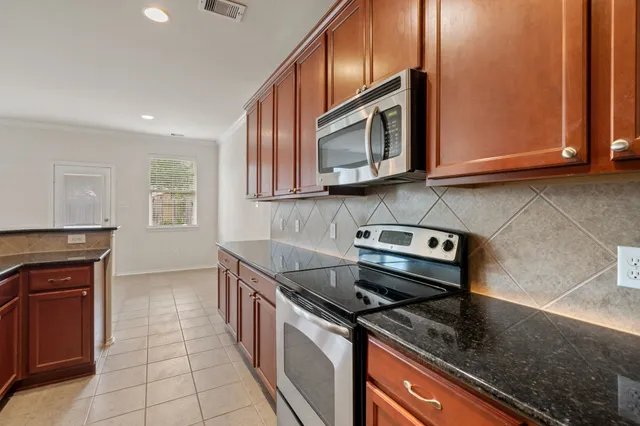 a kitchen with stainless steel appliances granite countertop a stove a sink and a microwave