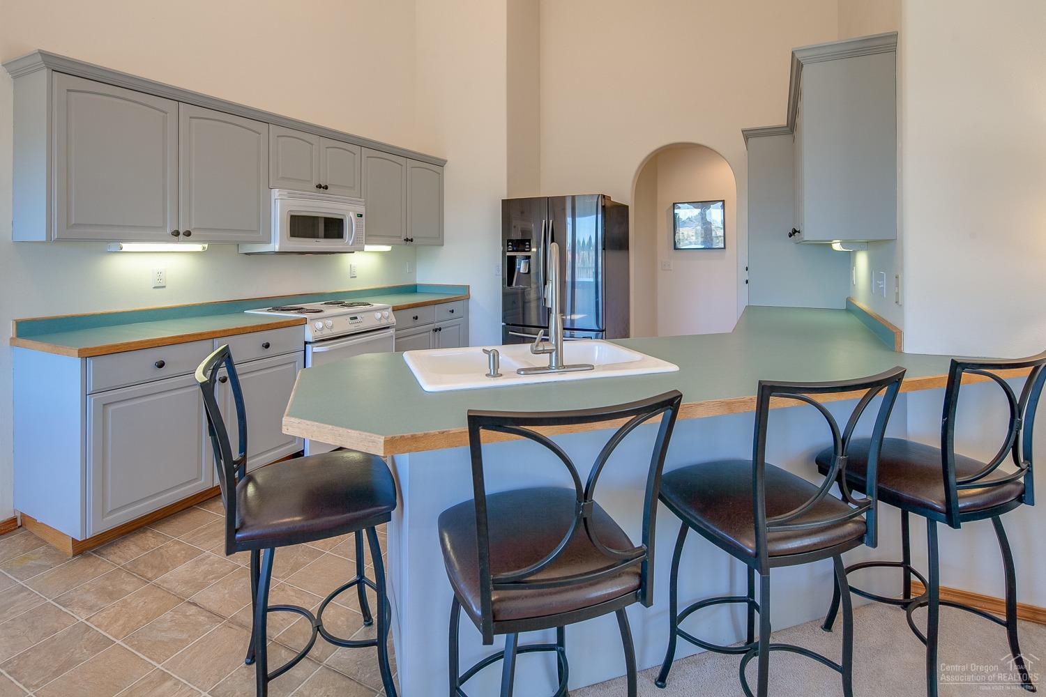 13990 South Sego Lily Road Powell Butte, OR 97753 - Photo 8 of 24 Roomy kitchen opens up to the family roo
