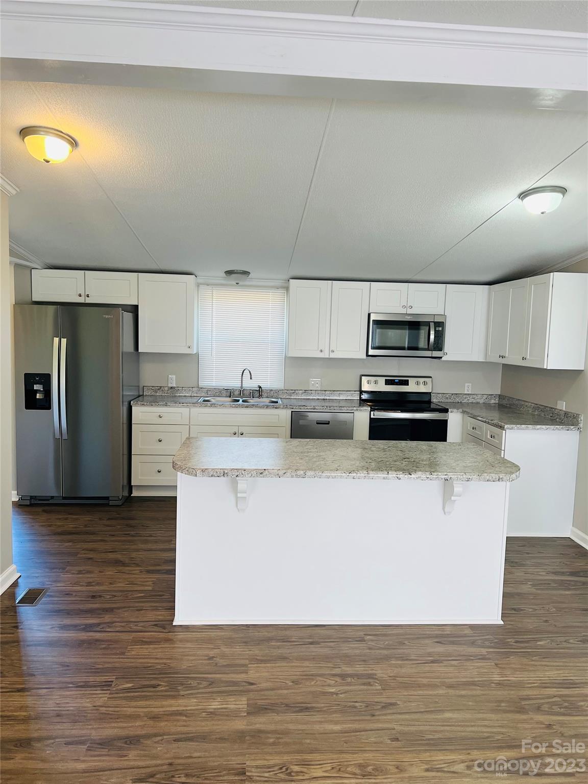 5310 Fallston Road Lawndale, NC 28090 - Photo 8 of 20 a kitchen with stainless steel appliances a refrigerator a stove a sink and white cabinets