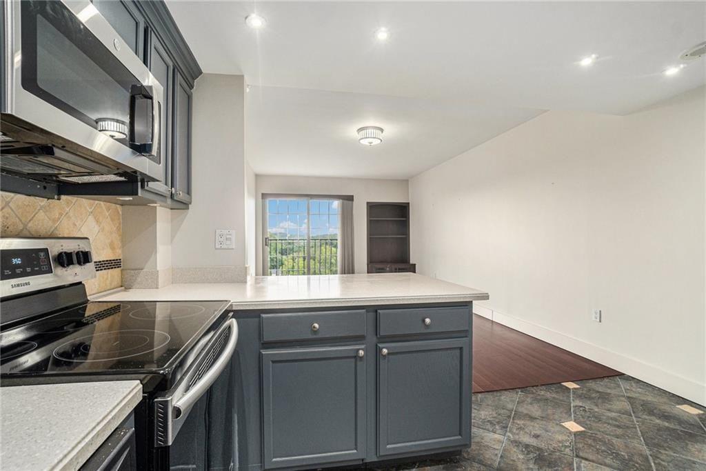 199 14th Street Northeast, Unit 704 Atlanta, GA 30309 - Photo 13 of 34 a kitchen with a sink a stove and cabinets
