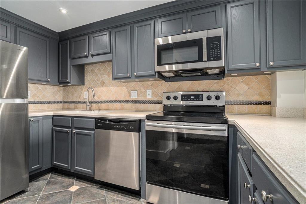 199 14th Street Northeast, Unit 704 Atlanta, GA 30309 - Photo 14 of 34 a kitchen with stainless steel appliances granite countertop a stove microwave and sink