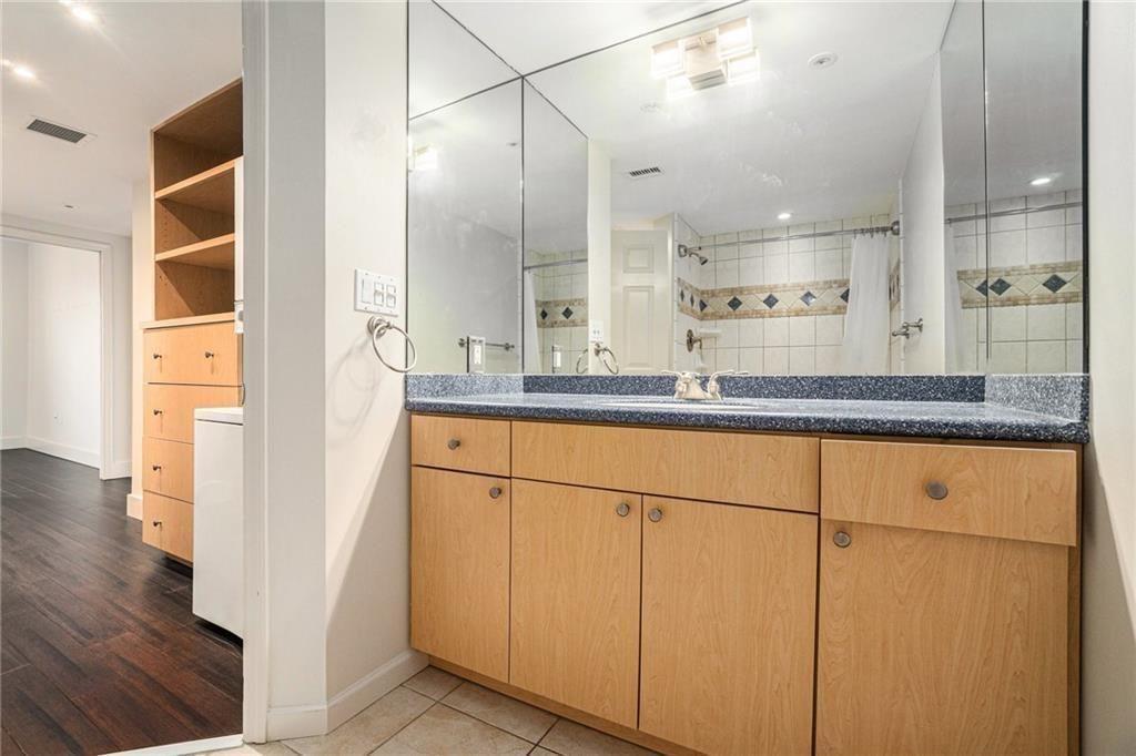 199 14th Street Northeast, Unit 704 Atlanta, GA 30309 - Photo 17 of 34 a bathroom with a granite countertop sink and a mirror