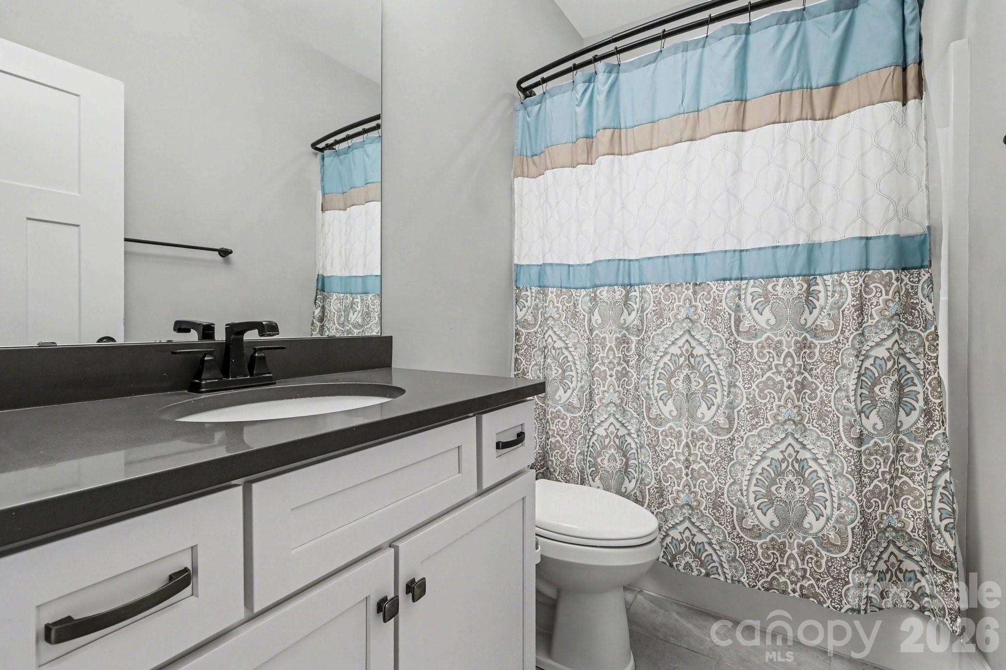 4193 Persimmon Road Lancaster, SC 29720 - Photo 25 of 42 a bathroom with a granite countertop sink and a toilet