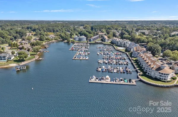 an aerial view of residential house with outdoor space and trees all around