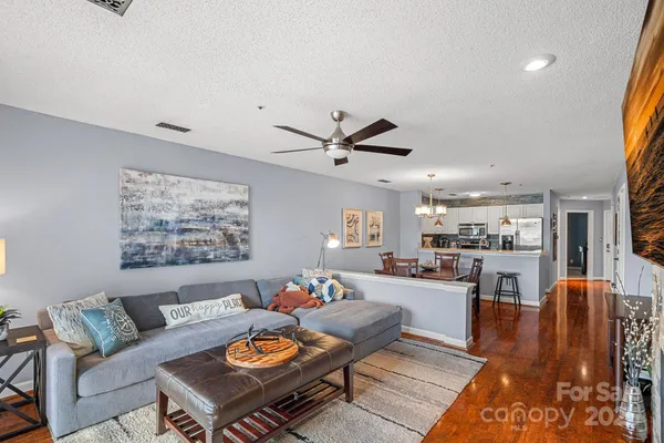 a living room with furniture and kitchen view
