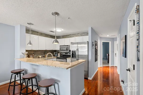 a kitchen with stainless steel appliances granite countertop a sink stove and refrigerator