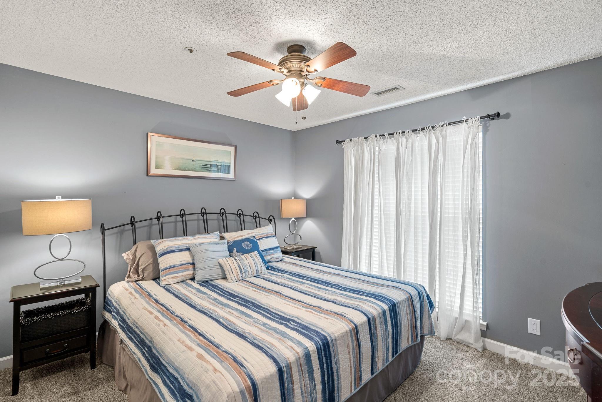 18673 Vineyard Point Lane Cornelius, NC 28031 - Photo 10 of 29 a bedroom with bed and a chandelier