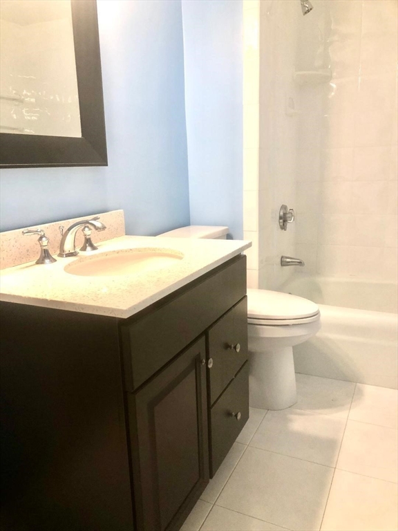 146 Marble Street, Unit 204 Stoneham, MA 02180 - Photo 16 of 21 a bathroom with a granite countertop sink a toilet and a bathtub