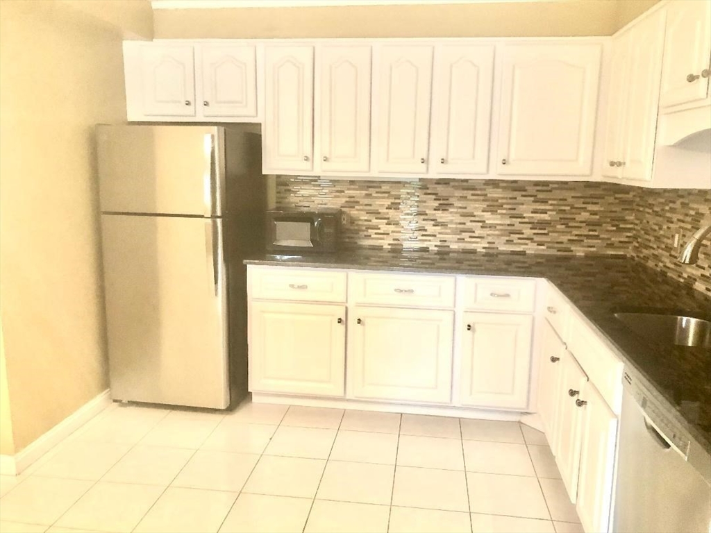 146 Marble Street, Unit 204 Stoneham, MA 02180 - Photo 5 of 21 a kitchen with a sink a refrigerator and a stove