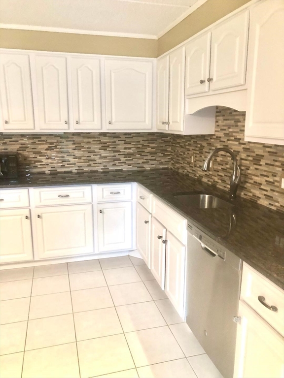 146 Marble Street, Unit 204 Stoneham, MA 02180 - Photo 6 of 21 a kitchen with granite countertop a sink a stove and cabinets