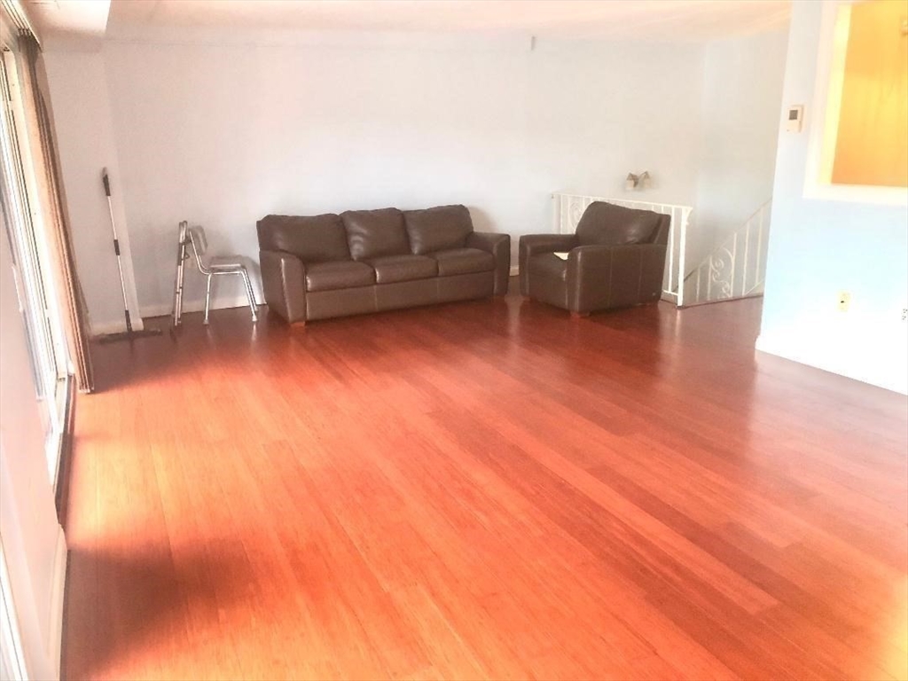 146 Marble Street, Unit 204 Stoneham, MA 02180 - Photo 7 of 21 a living room with furniture and a wooden floor