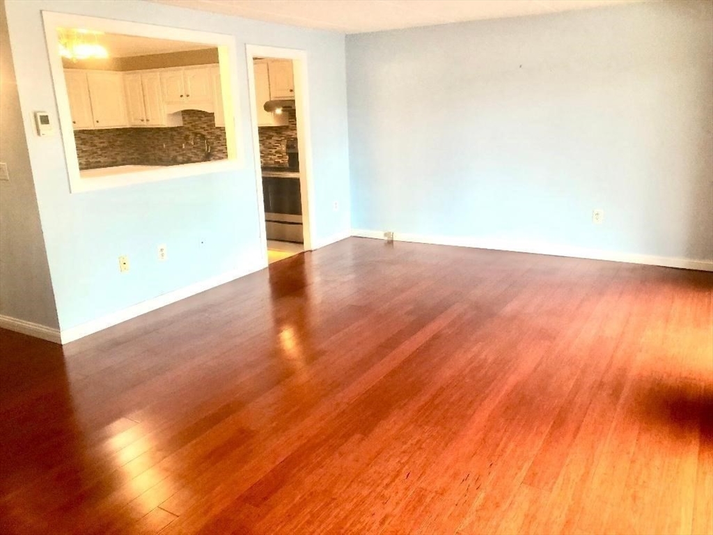 146 Marble Street, Unit 204 Stoneham, MA 02180 - Photo 8 of 21 a view of an empty room with wooden floor