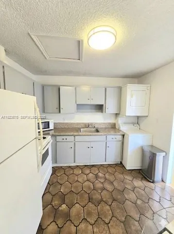 a kitchen with a sink window and cabinets