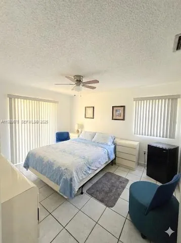 a bedroom with a bed couch and window