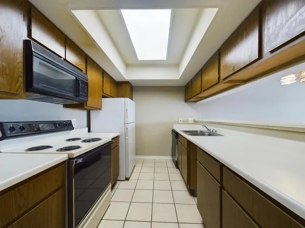 a kitchen with a stove sink and cabinets
