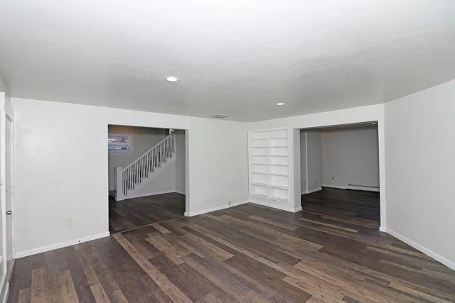 an empty room with wooden floor and closet